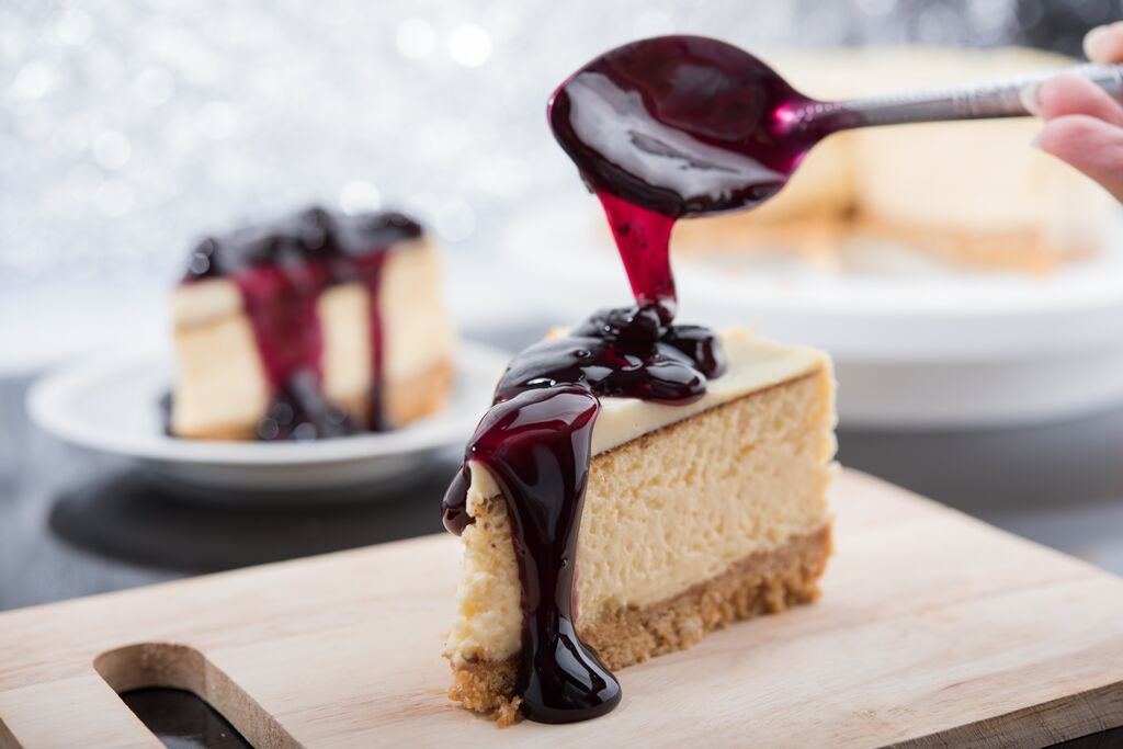 Blueberry cheesecake slice topped with glossy berry sauce.