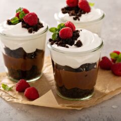 glass jar dessert with chocolate mousse, cream, and raspberries