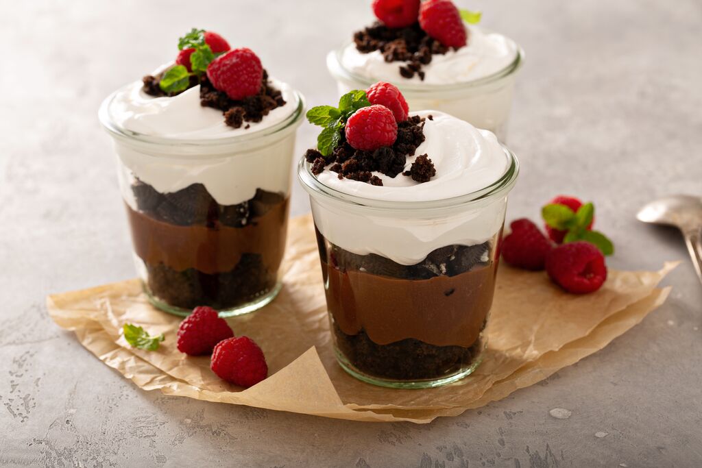 glass jar dessert with chocolate mousse, cream, and raspberries