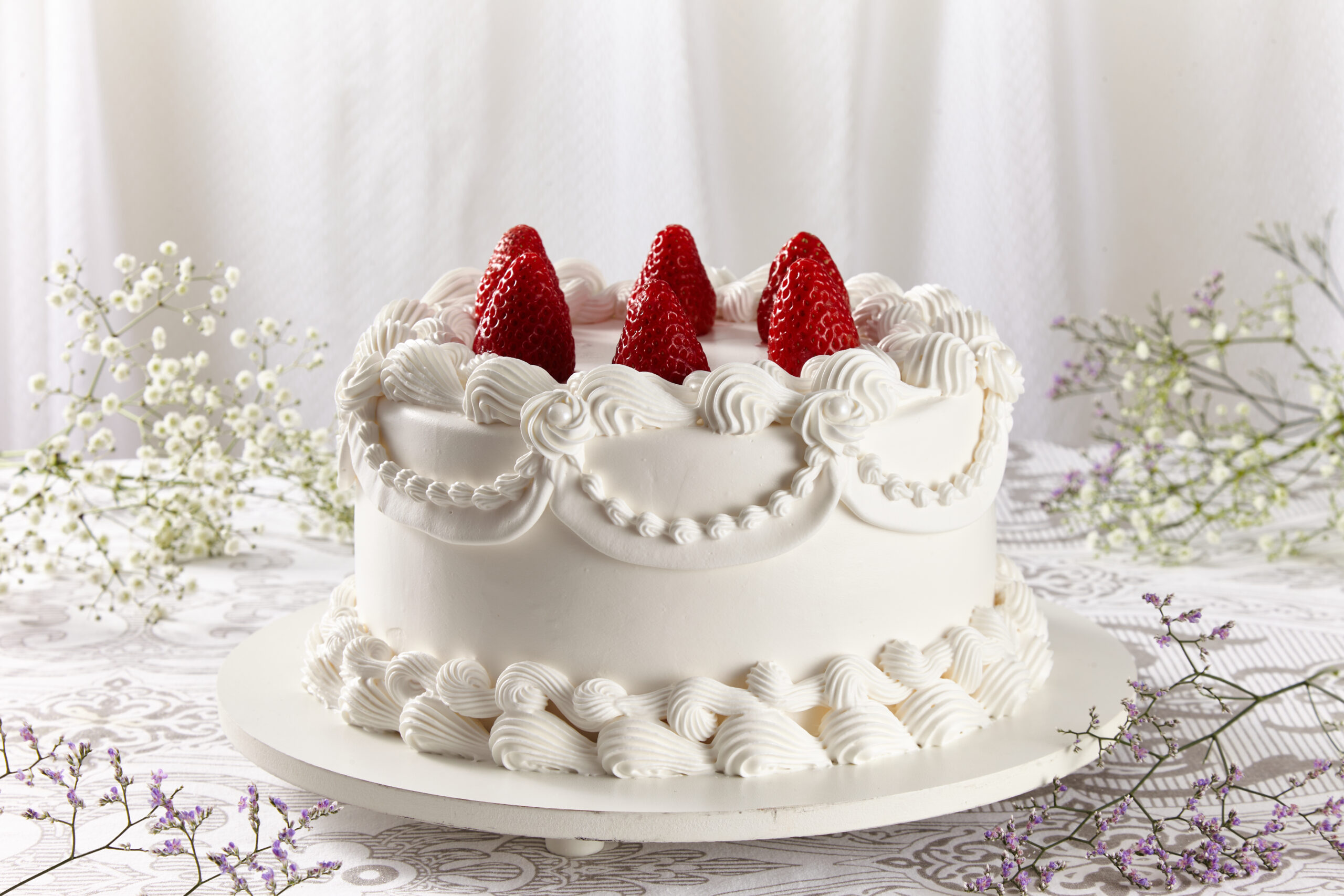 Classic white strawberry cake with fresh strawberries and whipped cream swirls