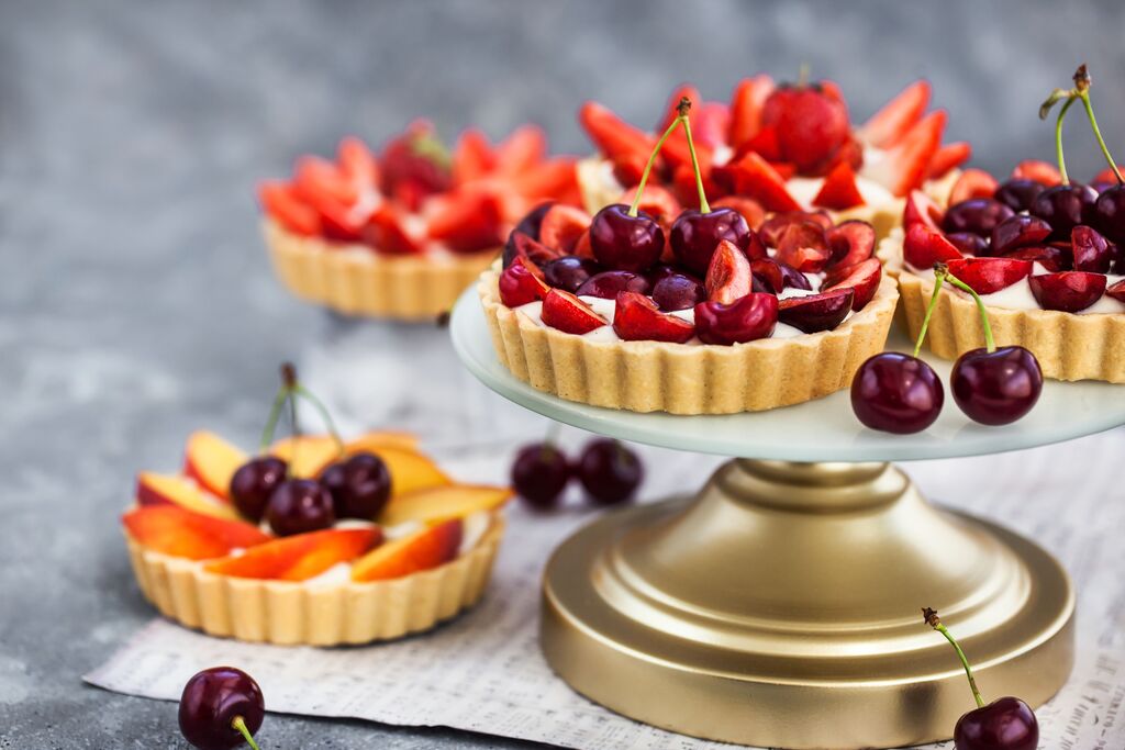 Fresh fruit tart topped with cherries and strawberries