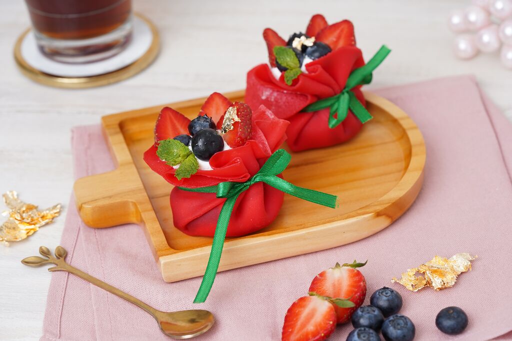 Red berry pouch cakes with strawberries, blueberries and cream.