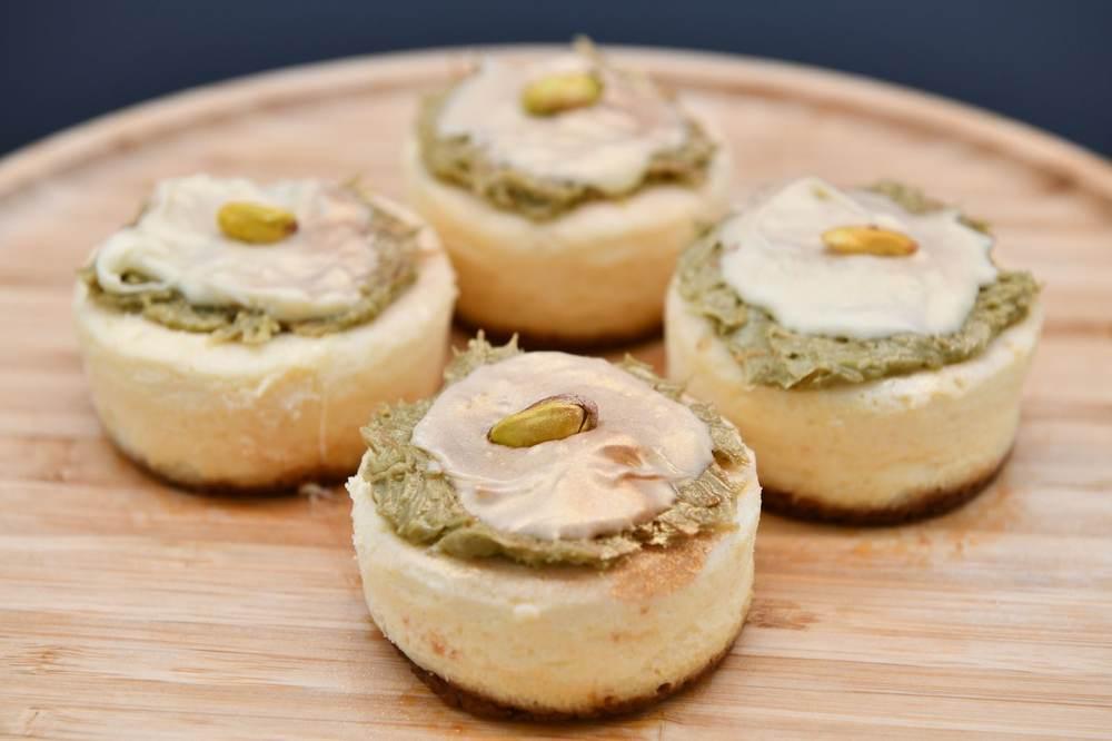 Mini pistachio cheesecakes topped with pistachio cream and whole pistachios