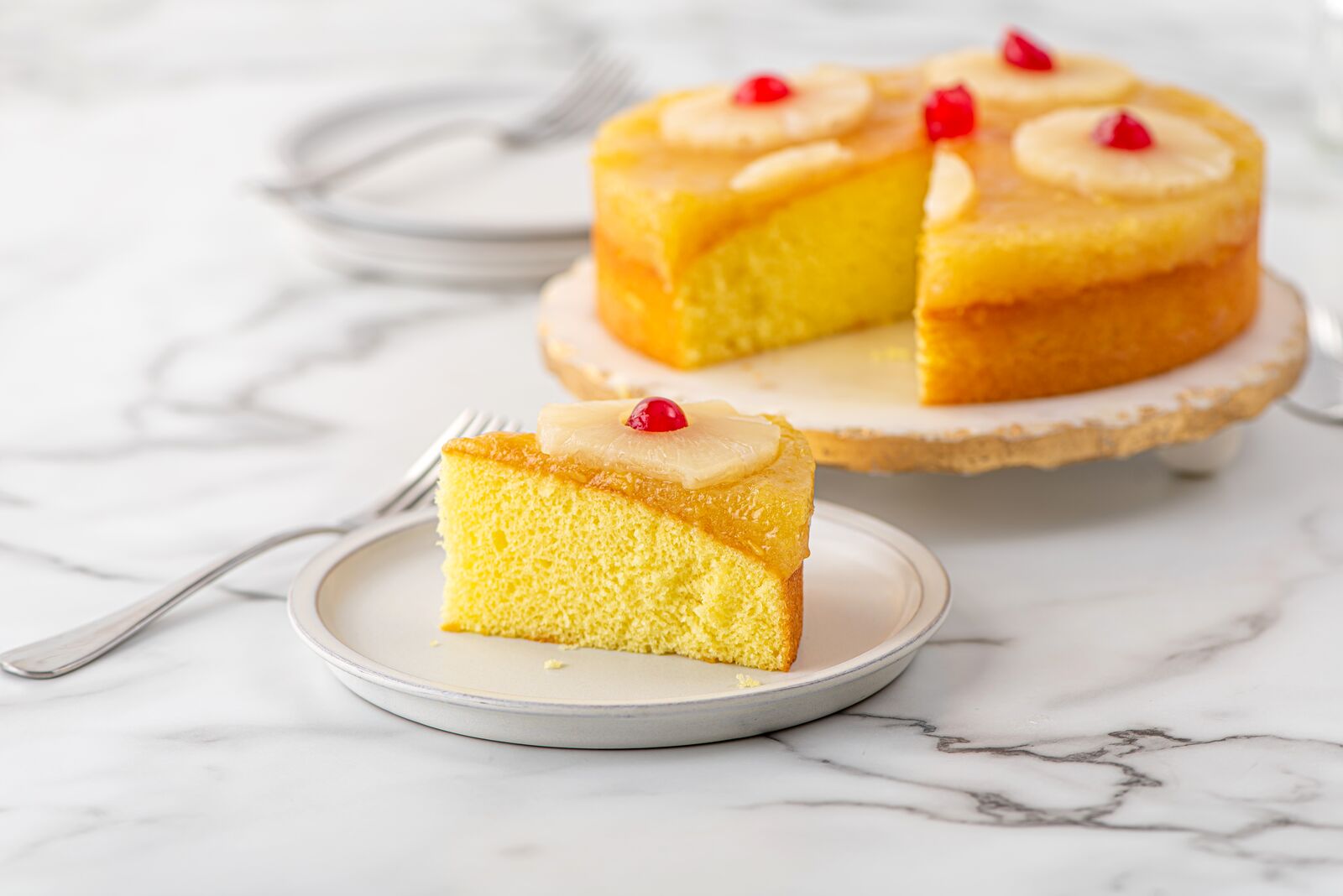 Pineapple cake slices topped with pineapple and cherries
