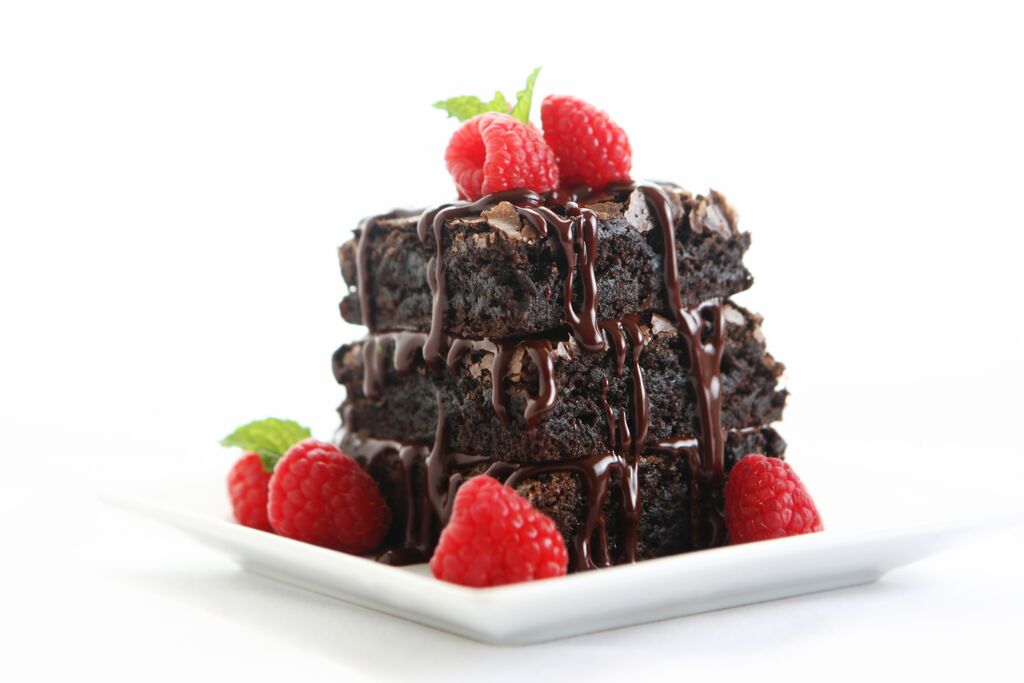 Chocolate brownie stack with ganache drip and raspberries