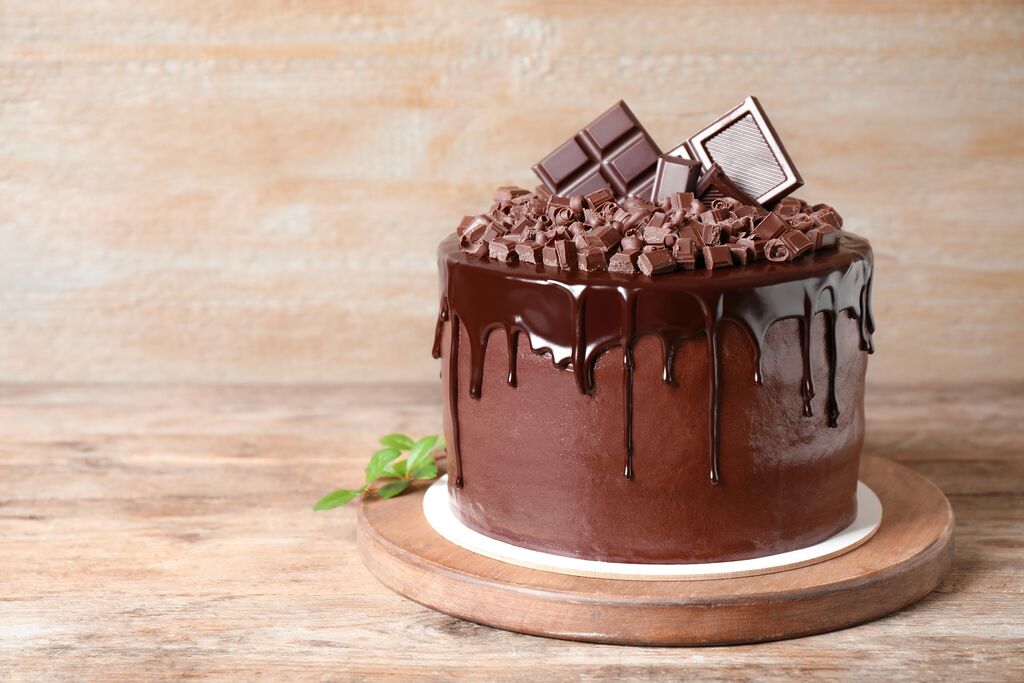 Chocolate drip cake topped with chocolate curls and bars