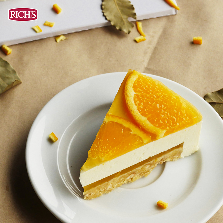 Orange cheesecake slice showing a set curd filling over a smooth cream layer