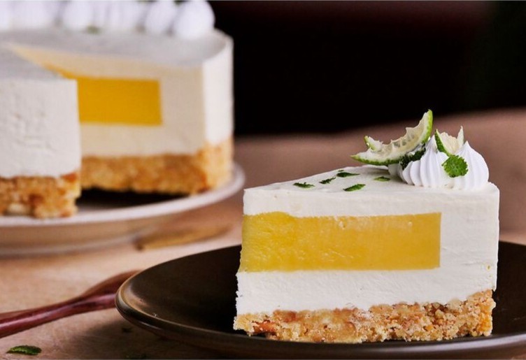 Cheesecake slice showing a neat, even fruit filling layer between cream and a biscuit base