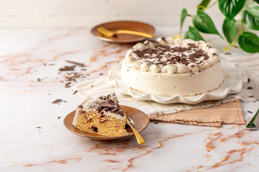 Cake with combed frosting sides, piped rosette border and chocolate shavings