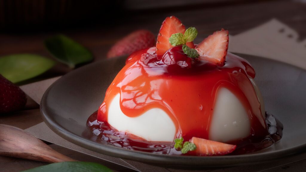 topped with strawberry sauce and fresh strawberries