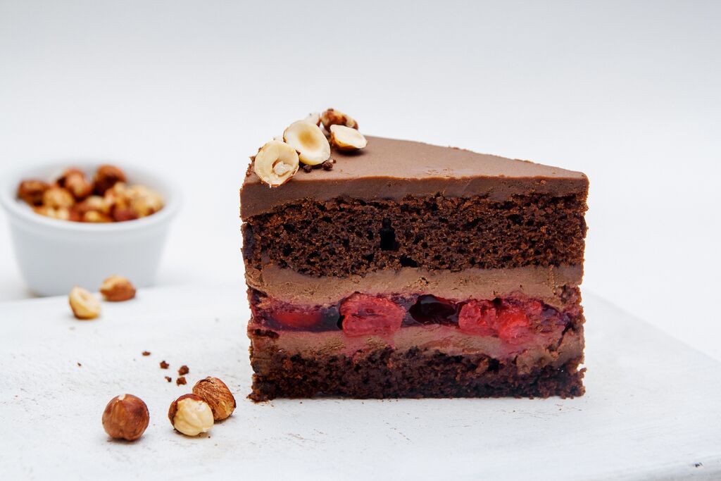 Chocolate cake slice with ganache coating and berry filling
