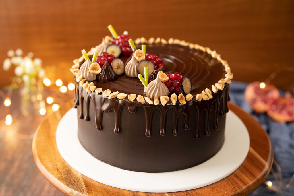 Chocolate cake topped with ganache truffles and hazelnuts