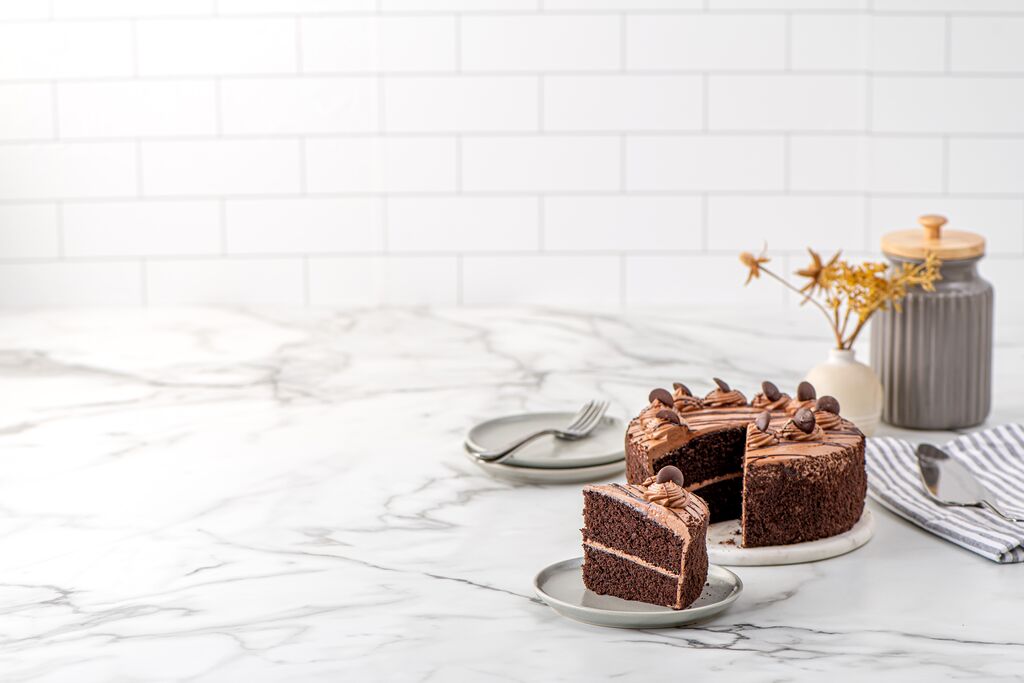 Cut chocolate ganache cake showing soft sponge layers
